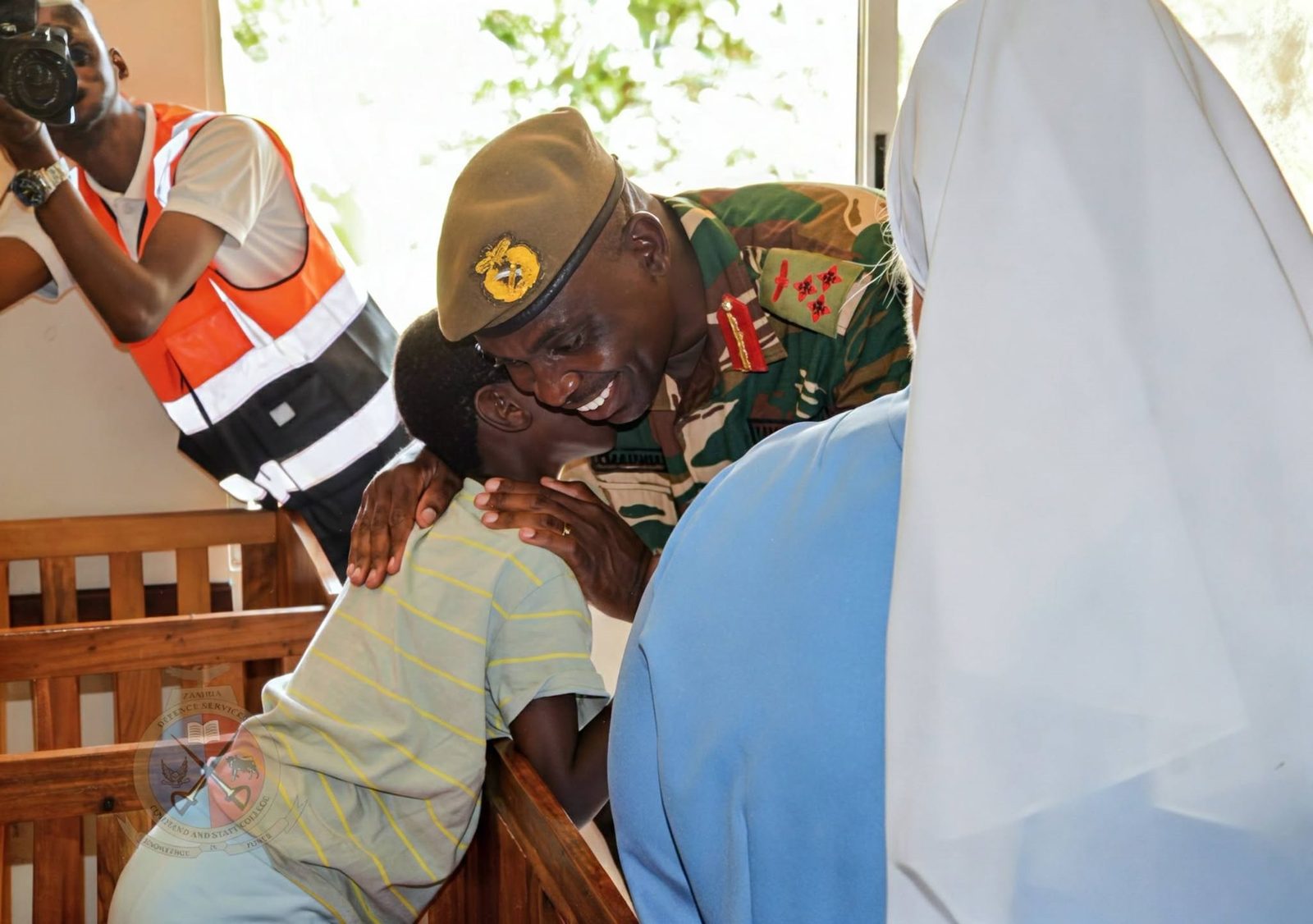 Brigadier General Samatamba warmly embracing a child at Kasisi