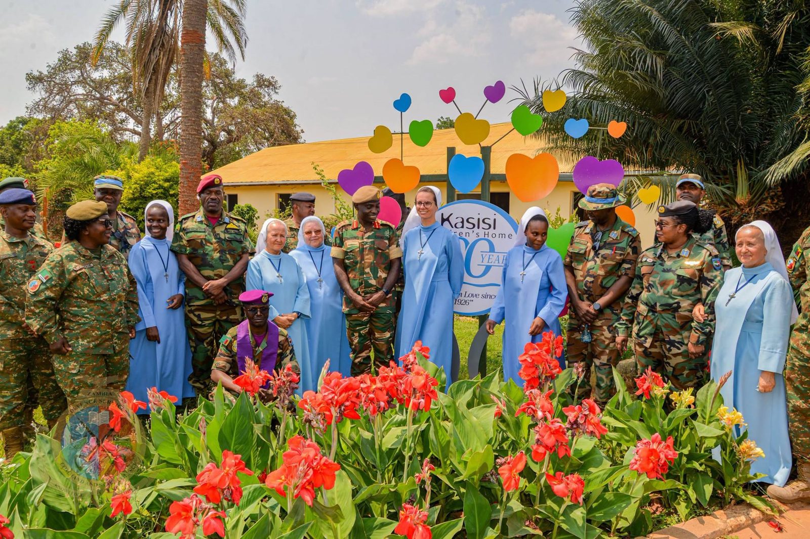 The Commandant, Sisters and officers beside the Kasisi 100 Years sign