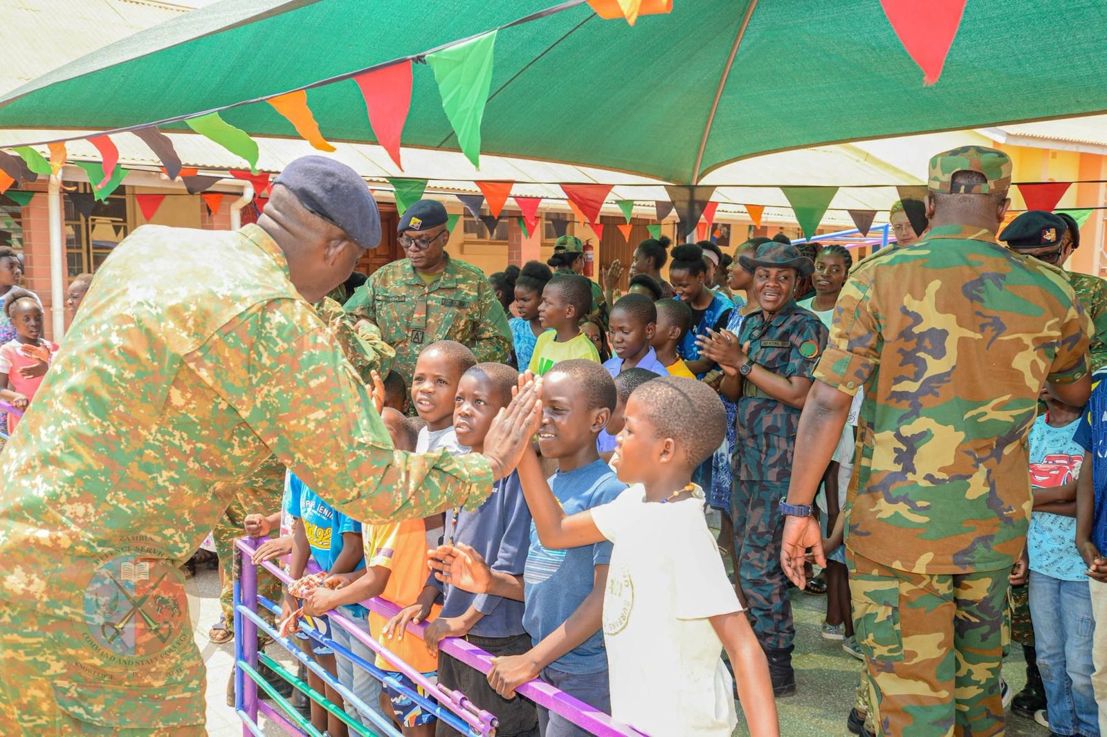 The Commandant greeting children with a high five