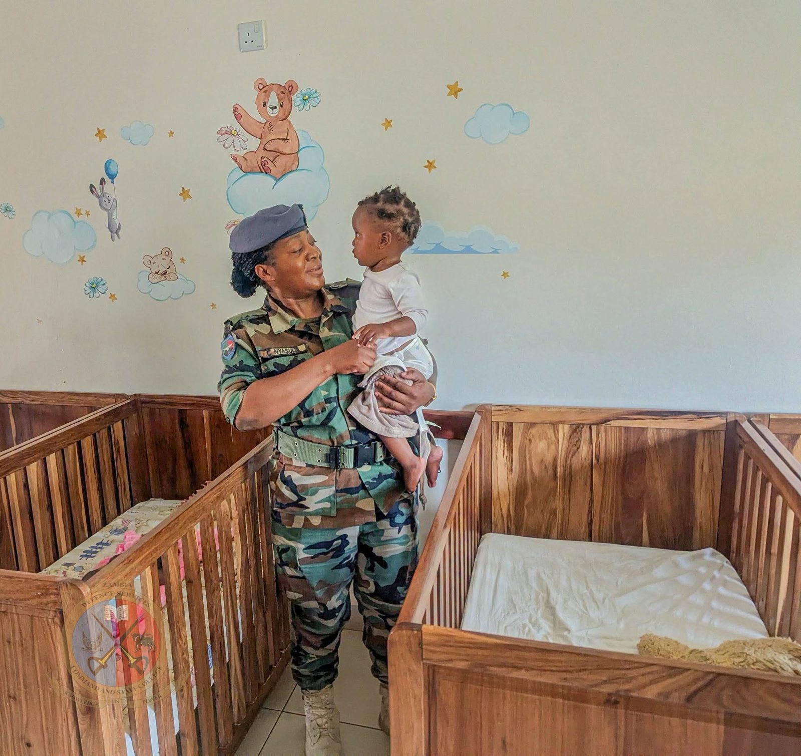 A Student Officer holding a baby in the nursery