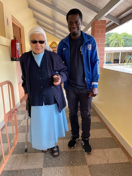 Sister Jolanta walking with a helper